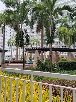 a white fence with palm trees in front of a building at 101-2Br-1bed quenn-1single-1-pullout 2 sofa 2-cr pool view with balcony in Manila