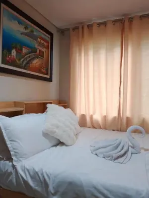 a bed with white towels on it with a window at 101-2Br-1bed quenn-1single-1-pullout 2 sofa 2-cr pool view with balcony in Manila