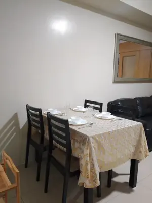 a dining room table with chairs and a tablecloth on it at 349-1br 1bed quenn 1sofa bed 2extra mattress moa view with balcony in Manila