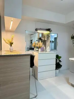 a kitchen with white cabinets and a counter with plants at SM Bicutan MNL in Manila