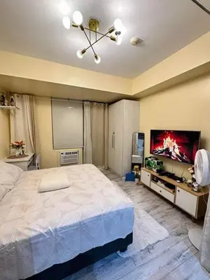 a bedroom with a large bed and a flat screen tv at SM Bicutan MNL in Manila