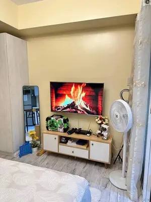 a living room with a fire painting on the wall at SM Bicutan MNL in Manila