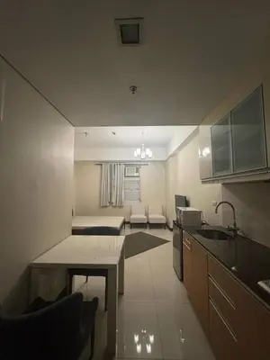 a kitchen and living room with a couch and a table at Condominium Studio Type in Manila