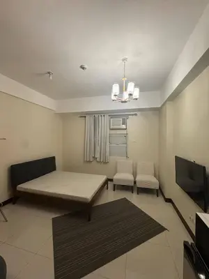 a living room with a couch and a tv at Condominium Studio Type in Manila