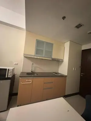a small kitchen with a sink and a microwave at Condominium Studio Type in Manila
