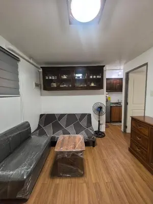 a living room with a black couch and a table at Ysabella's Abode in Manila