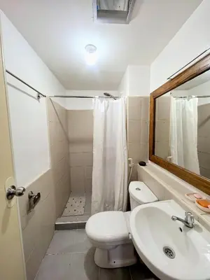 a bathroom with a toilet and a sink and a mirror at Ysabella's Abode in Manila