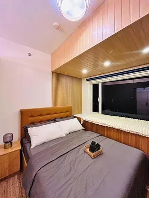 a bedroom with a large bed and a window at SolAzur Staycation SMDC South Residences Las Piñas with 100MBPS Wifi &NETFLIX &BAR STATION &CITY LIGHTS VIEW in Manila