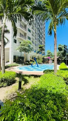 a swimming pool with a slide in front of a building at SolAzur Staycation SMDC South Residences Las Piñas with 100MBPS Wifi &NETFLIX &BAR STATION &CITY LIGHTS VIEW in Manila
