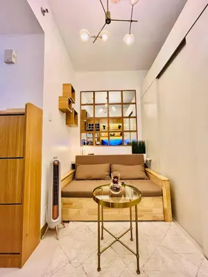 a living room with a couch and a table at SolAzur Staycation SMDC South Residences Las Piñas with 100MBPS Wifi &NETFLIX &BAR STATION &CITY LIGHTS VIEW in Manila