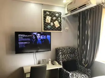 a room with a tv and a chair and a desk at BGC Urban Studio Prime Spot, Walk to Everything in Manila