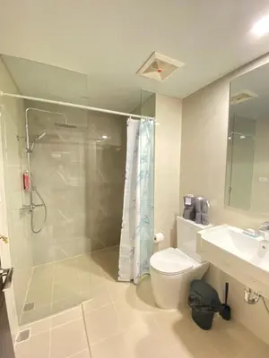 a bathroom with a shower and a toilet and a sink at A1 Suite in McKinley in Manila