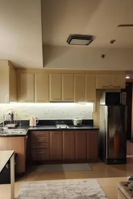 a kitchen with wooden cabinets and a stainless steel refrigerator at The Venice Luxury Residences Condominium 28B Bellini, McKinley Hill, Taguig City, Philippines in Manila