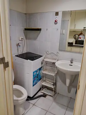 a small bathroom with a toilet and a sink at Sea Residence Tower by let's Bareds in Manila