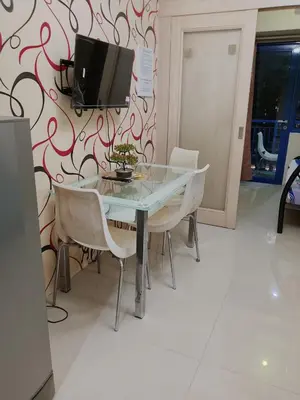 a dining room table with chairs and a tv on a wall at Sea Residence Tower by let's Bareds in Manila