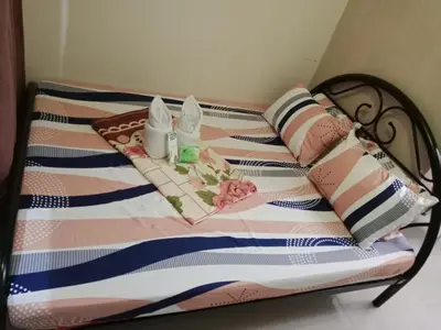a bed with a striped blanket and pillows on it at Sea Residence Tower by let's Bareds in Manila