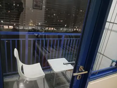 a white chair sitting on a balcony with a window at Sea Residence Tower by let's Bareds in Manila