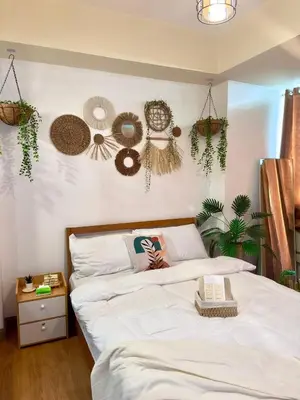 a bedroom with a bed with plants on the wall at SM Bicutan Condotels by Sibs in Manila