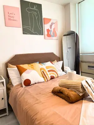 a bedroom with a large bed with orange sheets at SM Bicutan Condotels by Sibs in Manila