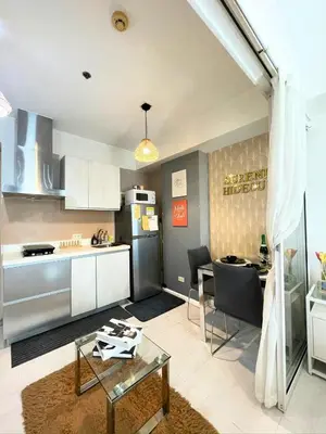 a kitchen and living room with a table and a refrigerator at SM Bicutan Condotels by Sibs in Manila