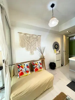 a bedroom with a bed with two pillows on it at SM Bicutan Condotels by Sibs in Manila