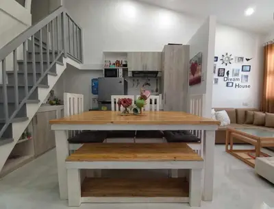 a living room with a table and a staircase at Tanza Cavite Staycation Condo Loft in Tanza