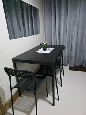 a black table with two chairs and a vase on it at Aloha Escape for Coffee Lovers in Manila