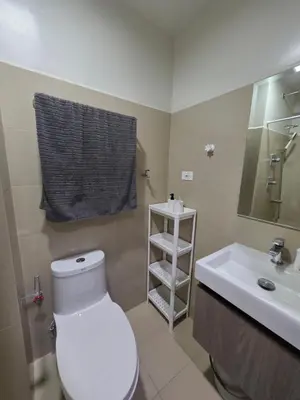 a bathroom with a white toilet and a sink at Aloha Escape for Coffee Lovers in Manila