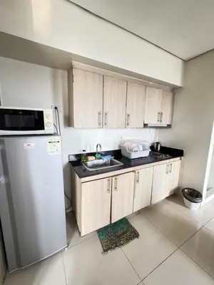 a kitchen with a sink and a refrigerator at Breeze Deluxe Unit Roxas blvd in Manila