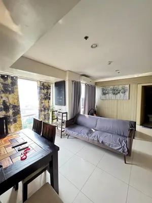 a living room with a couch and a table at Breeze Deluxe Unit Roxas blvd in Manila