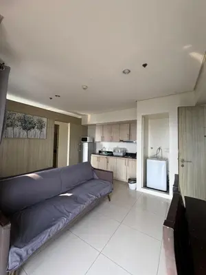 a living room with a couch and a kitchen at Breeze Deluxe Unit Roxas blvd in Manila