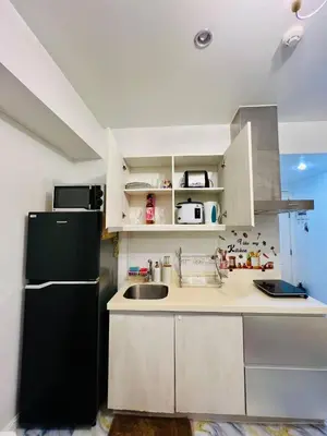 a kitchen with a black refrigerator and a sink at AZURE STAYCATION by TALA in Manila