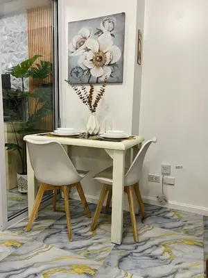 a dining room table with two chairs and a vase at AZURE STAYCATION by TALA in Manila