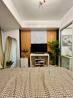 a bedroom with a bed and a flat screen tv at AZURE STAYCATION by TALA in Manila