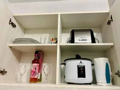 a cabinet with a coffee maker and a toaster and glasses at AZURE STAYCATION by TALA in Manila
