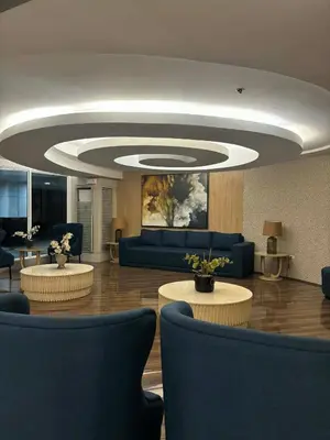a lobby with couches and tables in a room at Mall of Asia Staycation in Manila
