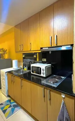 a kitchen with a microwave and a sink at Mall of Asia Staycation in Manila