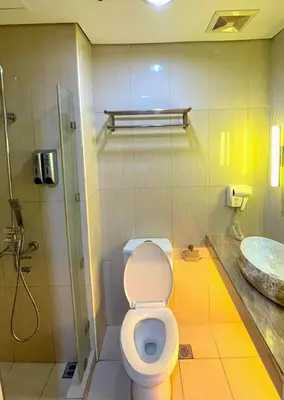 a bathroom with a toilet and a sink at Mall of Asia Staycation in Manila