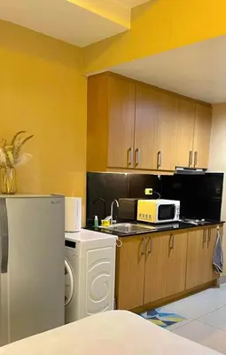 a kitchen with a white refrigerator and a microwave at Mall of Asia Staycation in Manila