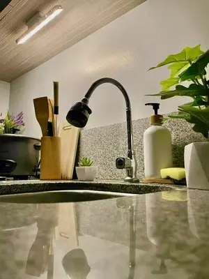a kitchen counter with a kitchen sink with a faucet at Amari Staycation - Alabang in Manila