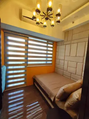 a bedroom with a bed and a chandelier at Casa Mexico at Air Residences Makati in Manila