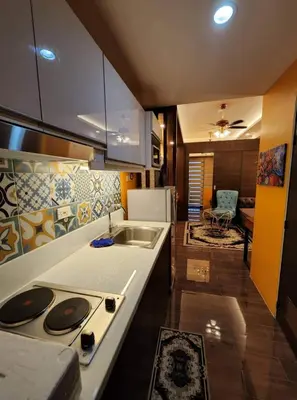 a kitchen with a sink and a stove top oven at Casa Mexico at Air Residences Makati in Manila