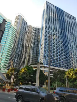 a car driving down a street in front of tall buildings at Casa Mexico at Air Residences Makati in Manila