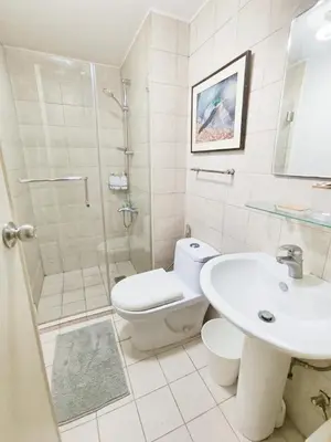 a bathroom with a toilet and a sink and a shower at The Crash Pad Soho Central in Manila