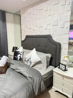 a bedroom with a large bed with white pillows at SM Bicutan Azure Flat in Manila