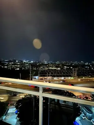 a moon over a city at night with traffic at SM Bicutan Azure Flat in Manila