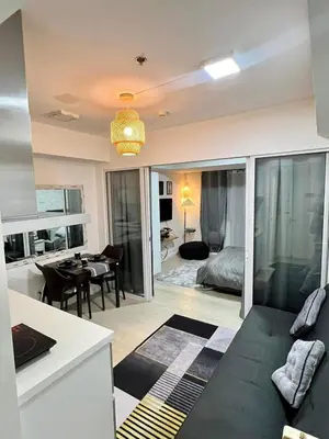 a living room with a couch and a bedroom at SM Bicutan Azure Flat in Manila