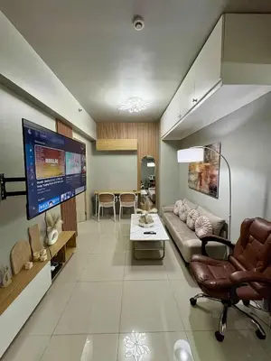 a living room with a couch and a tv at 2 Bedroom Unit at Central Makati in Manila
