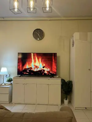 a fireplace in a living room with a clock on the wall at Casa En El Sur in Santa Rosa
