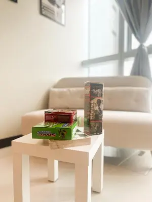 a white coffee table with books on it next to a couch at Uptown District Stay in Manila